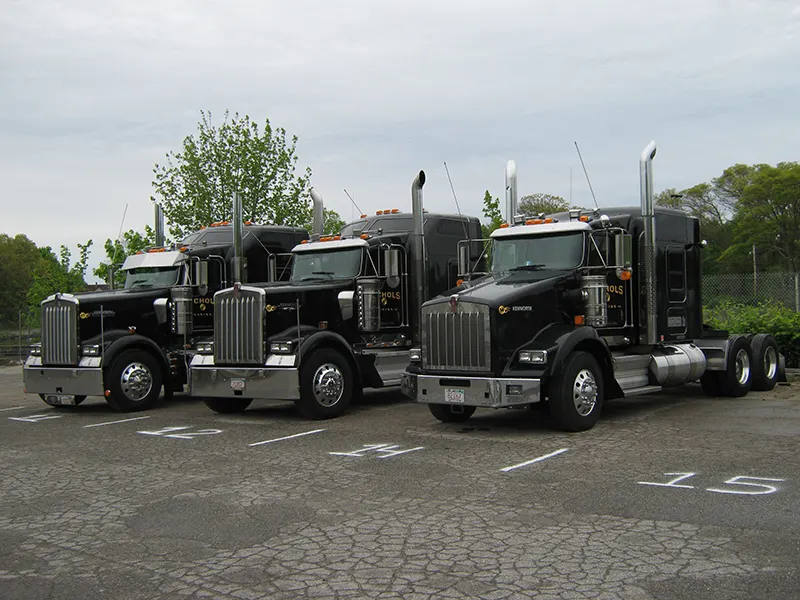 Three black Nichols Kenworth tractors lined up in the lot